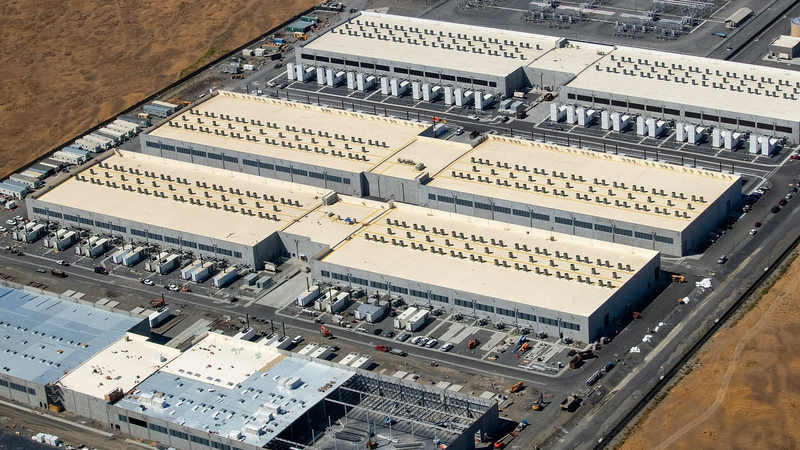 An aerial view of three large Amazon Web Services data centre buildings in Oregon, with a fourth under construction.