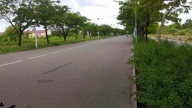 A road in Hulhumalé, Maldives, with buildings and vehicles along both sides.