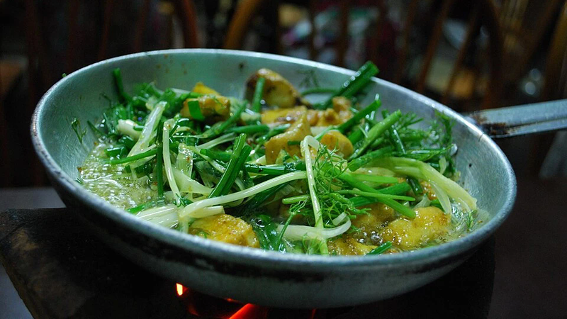 Rice cooked with fish and green leaves.