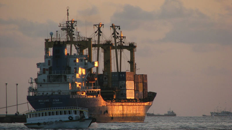 A container cargo ship off Fonadhoo island in the Maldives at sunset