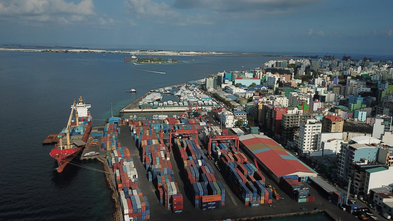 Aerial view of the port of Malé with cargo ships, container yard and dense city skyline beside the Indian Ocean