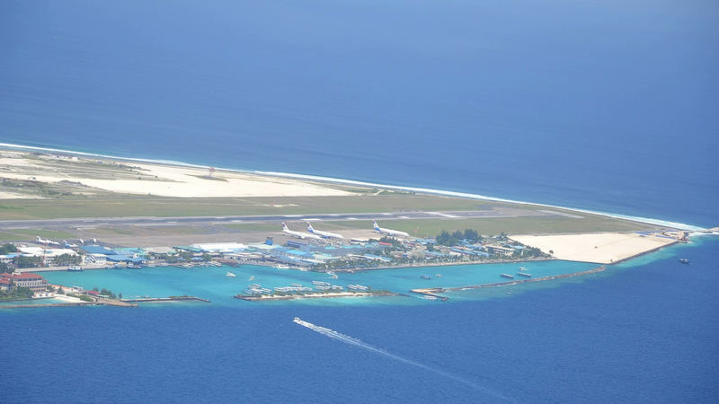 Aerial view of Velana International Airport on Hulhulé island with aircraft parked beside the runway