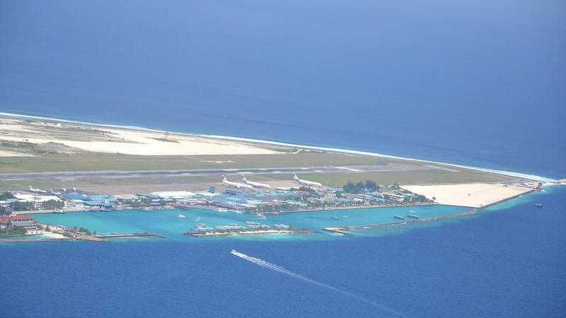 Aerial view of Velana International Airport on Hulhulé island with aircraft parked beside the runway