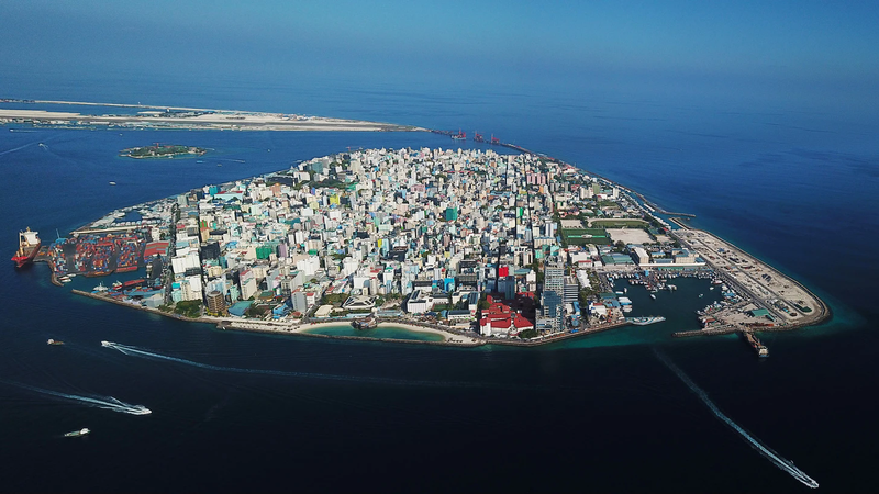 Aerial view of the densely built island of Malé with harbour areas and surrounding blue ocean