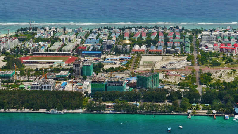 Aerial view of Hulhumalé showing housing blocks, a stadium and construction sites beside the lagoon