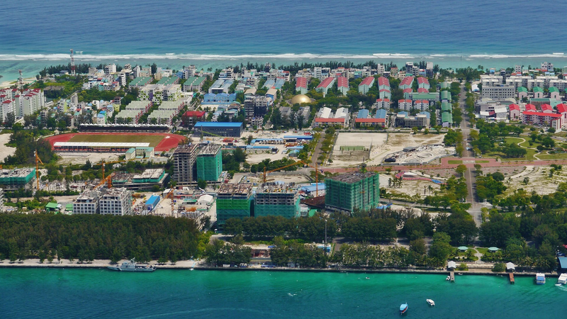 Aerial view of Hulhumalé showing housing blocks, a stadium and construction sites beside the lagoon