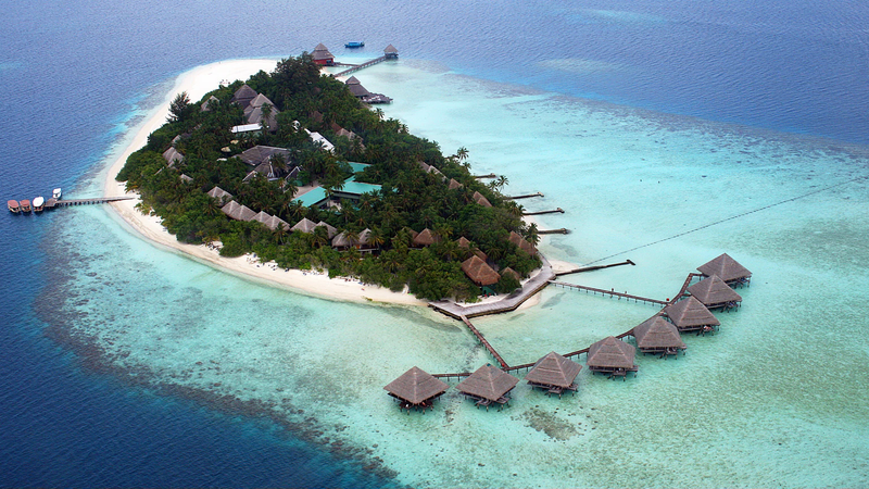 Aerial view of a Maldives island on a coral reef with turquoise lagoon
