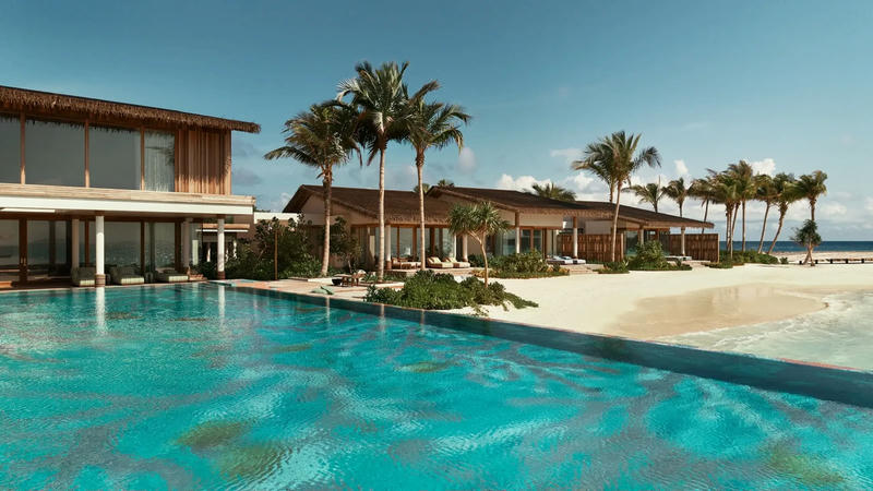 Infinity pool in front of a two-storey thatched residence and palm trees on a white-sand beach, Nowhere Private Island, Maldives